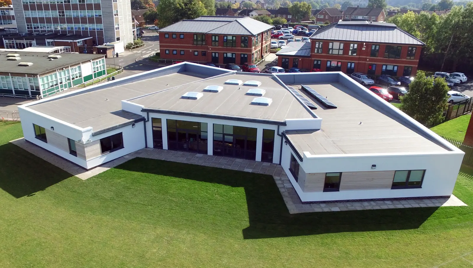 Modular school building surrounded by grass field, photographed from above